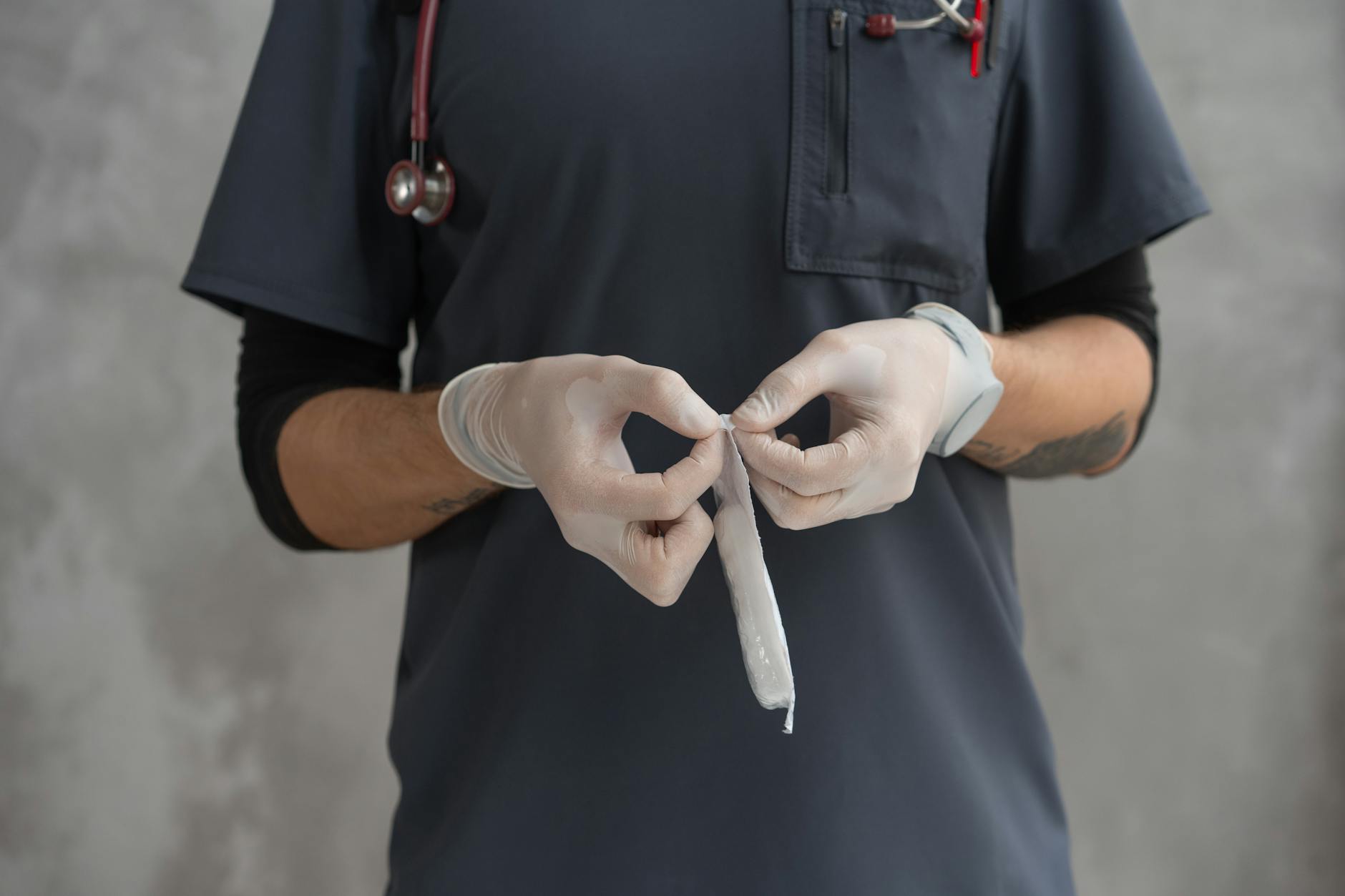 Healthcare professional wearing gloves preparing a medical gauze, emphasizing hygiene and readiness.