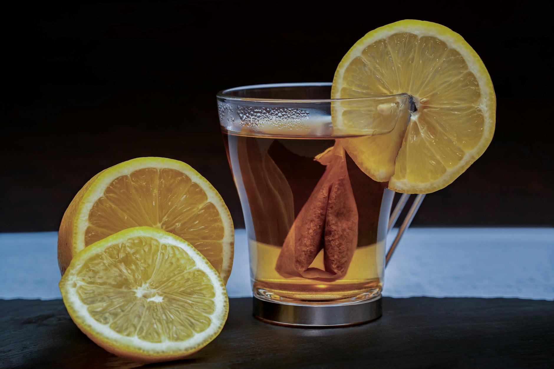 Invigorating lemon ginger tea in a glass, adorned with fresh lemon slices for added zest.